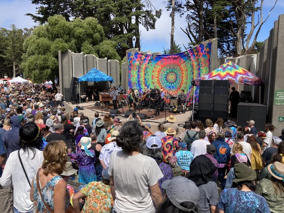 Crowd watching the band, Stu Allen & Mars Hotel performing on the tie-dye draped stage at  the Jerry Garcia Amphitheater.  Jerry Day 2025 in San Francisco's McLaren Park